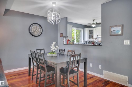 Spacious dining area featuring wood-finish flooring and a contemporary overhead light fixture - #47 2505 42 St Nw, Edmonton, AB 