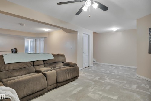 Spacious lower-level area featuring light-toned walls, recessed lighting, a ceiling fan with integrated lighting, and light grey patterned flooring - #47 2505 42 St Nw, Edmonton, AB 