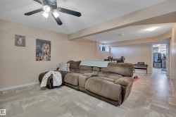 Spacious lower-level room featuring light-toned walls and wood-finish flooring - 
