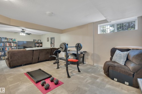 Versatile lower-level space featuring light-toned flooring, recessed lighting, and a window for natural light - #47 2505 42 St Nw, Edmonton, AB 