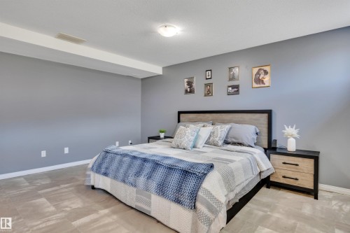 Spacious bedroom featuring light gray walls, white trim, and light-toned tile flooring - #47 2505 42 St Nw, Edmonton, AB 