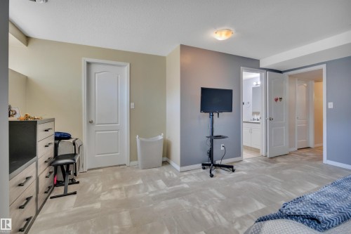 Spacious interior featuring light-toned flooring, neutral wall colors, and a ceiling-mounted light fixture - #47 2505 42 St Nw, Edmonton, AB 