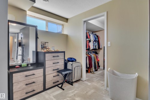 Recessed window with natural light, neutral wall colors, and a walk-in closet with ample hanging space - #47 2505 42 St Nw, Edmonton, AB 
