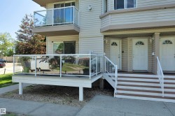 Exterior featuring beige horizontal siding, white trim, and multiple entryways - 