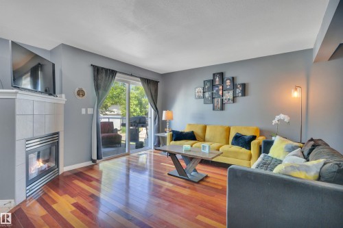 Living area featuring wood-finish flooring and grey wall tones - #47 2505 42 St Nw, Edmonton, AB 