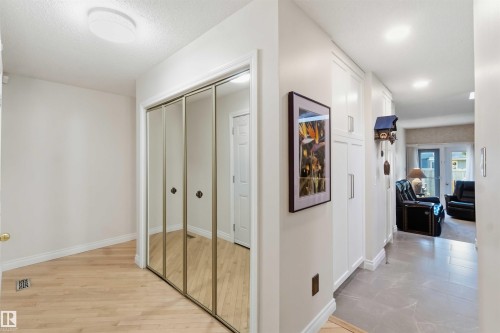 Entryway featuring mirrored closet doors, wood-finish flooring, and recessed lighting - 31 Gariepy Crescent, Edmonton, AB 