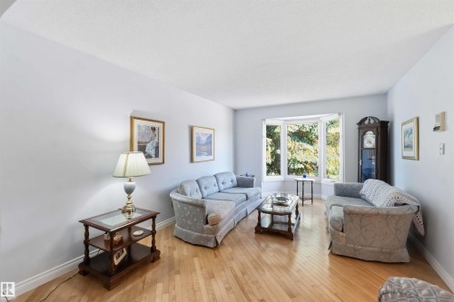 Bright living area featuring light-toned walls and wood-finish flooring - 31 Gariepy Crescent, Edmonton, AB 