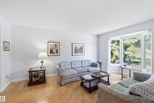 Bay window with a bright outdoor backdrop, light wood-finish flooring, and white baseboards - 31 Gariepy Crescent, Edmonton, AB 
