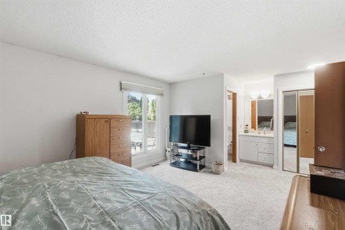 Spacious room with light neutral walls, plush carpeting, and a large window providing ample natural light - 31 Gariepy Crescent, Edmonton, AB 