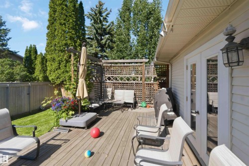 Expansive wood deck with a privacy lattice, offering direct access to the interior via double French doors - 31 Gariepy Crescent, Edmonton, AB 
