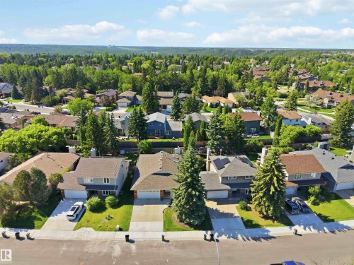 Aerial perspective showcasing a residential neighborhood with diverse housing styles, mature trees, and paved streets - 31 Gariepy Crescent, Edmonton, AB 