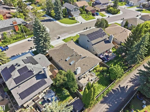 Aerial view of a residential property featuring solar panels on the roof, a backyard with a deck, and mature trees - 31 Gariepy Crescent, Edmonton, AB 
