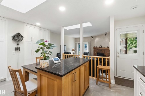 Kitchen featuring a central island with a dark countertop and natural wood cabinetry - 31 Gariepy Crescent, Edmonton, AB 