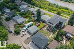 Modern multi-level residence featuring a dark shingle roof, extensive window lines, and a light-toned exterior - 