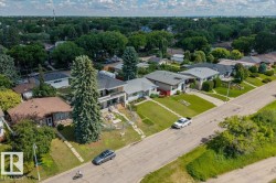 Residential area featuring a mix of housing styles, mature trees, and paved streets - 
