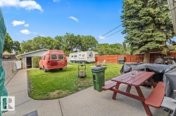Expansive grass lawn with mature perimeter trees and a concrete patio - 