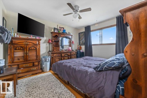 Bright bedroom featuring wood-finish flooring and a ceiling fan - 4622 Ada Boulevard, Edmonton, AB 