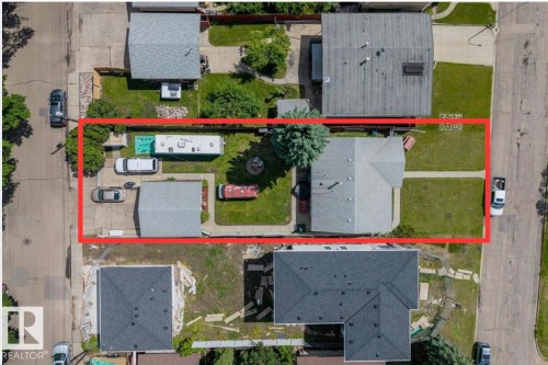 Property featuring a detached garage, a paved driveway, and a front lawn with a concrete walkway - 4622 Ada Boulevard, Edmonton, AB 