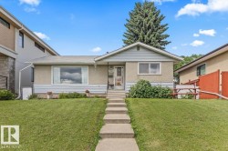 Front exterior featuring a concrete walkway, established front lawn, stucco and siding facade, covered entry, and mature landscaping - 