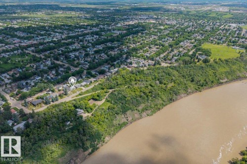 Aerial perspective showcasing a residential neighborhood with mature trees bordering a river - 4622 Ada Boulevard, Edmonton, AB 