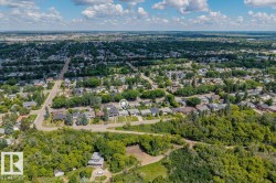 Aerial perspective of a residential neighborhood featuring established homes and abundant tree cover - 