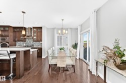 Open-concept kitchen and dining area featuring rich wood-finish flooring - 
