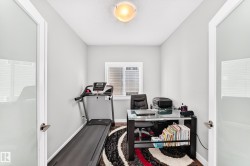 Compact room featuring wood-finish flooring, a window with horizontal blinds, and a ceiling-mounted light fixture - 