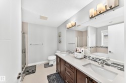 Bathroom featuring a dual vanity with a light countertop, dark wood-finish cabinetry, and contemporary vessel sinks - 