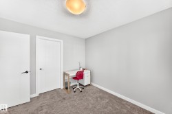 Neutral-toned room featuring a textured ceiling, flush-mount ceiling light, and light gray wall paint - 
