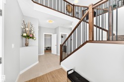 Grand staircase featuring wood-finish handrails and black metal balusters - 