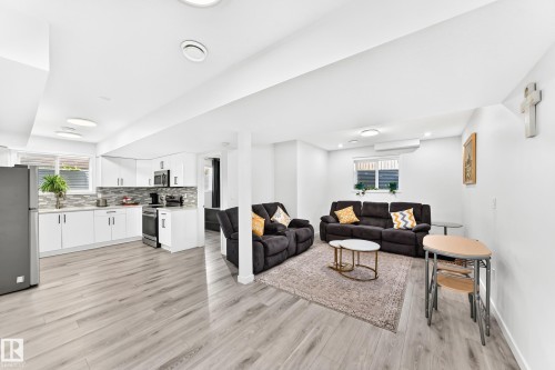 Open-concept living space featuring wood-finish flooring, recessed lighting, and a white color palette - 3672 Claxton Place, Edmonton, AB 