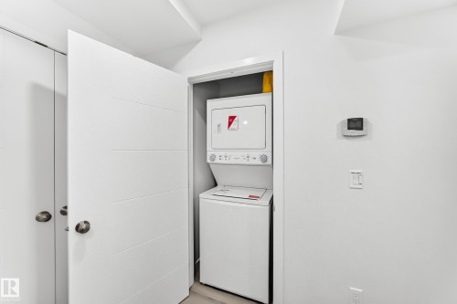 Dedicated laundry closet featuring a stacked washer and dryer unit - 3672 Claxton Place, Edmonton, AB 