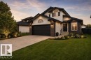 Contemporary residence featuring a blend of brick and siding, a dark garage door, and a concrete driveway - 362 Blackburn Drive, Edmonton, AB 