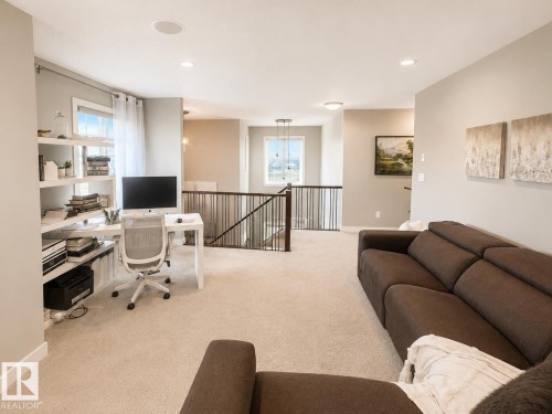 Spacious upper-level landing featuring plush carpeting, recessed lighting, and built-in shelving - 1004 Huckell Pl Sw, Edmonton, AB - Indoor