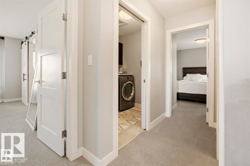Hallway featuring light gray carpeting, white baseboards, and white interior doors with contemporary hardware - 1004 Huckell Pl Sw, Edmonton, AB - Indoor Photo Showing Other Room