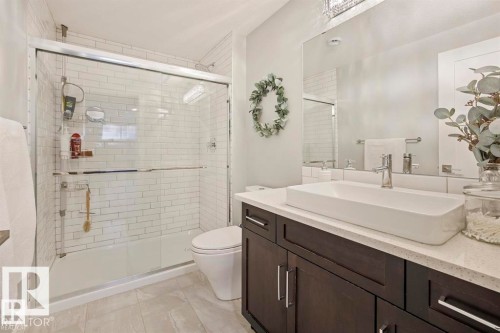 Contemporary bathroom featuring a dark wood-finish vanity with a white countertop and a rectangular vessel sink - 1004 Huckell Pl Sw, Edmonton, AB - Indoor Photo Showing Bathroom