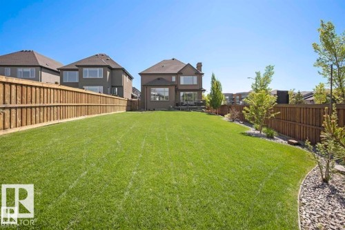Expansive green lawn with a wooden perimeter fence - 1004 Huckell Pl Sw, Edmonton, AB - Outdoor