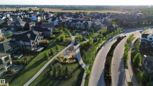 Expansive residential development featuring mature landscaping, paved roadways, and a communal park space - 1004 Huckell Pl Sw, Edmonton, AB - Outdoor With View