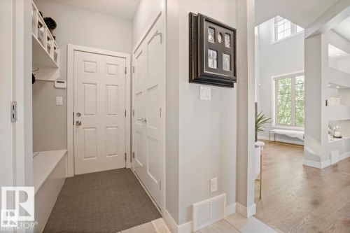 Entryway featuring built-in bench seating with cubby storage, a six-panel door, and an adjacent paneled door - 1004 Huckell Pl Sw, Edmonton, AB - Indoor Photo Showing Other Room