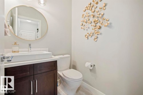 Modern vanity featuring a vessel sink, single-handle chrome faucet, and dark wood-finish cabinetry - 1004 Huckell Pl Sw, Edmonton, AB - Indoor Photo Showing Bathroom