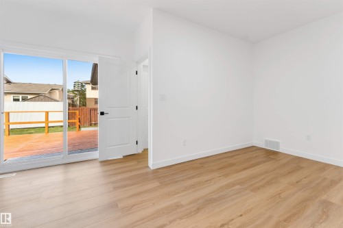 Light wood-finish flooring with white baseboards and walls - 5512 150 Avenue, Edmonton, AB 