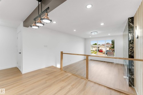 Contemporary open-concept interior featuring light wood-finish flooring - 5512 150 Avenue, Edmonton, AB 