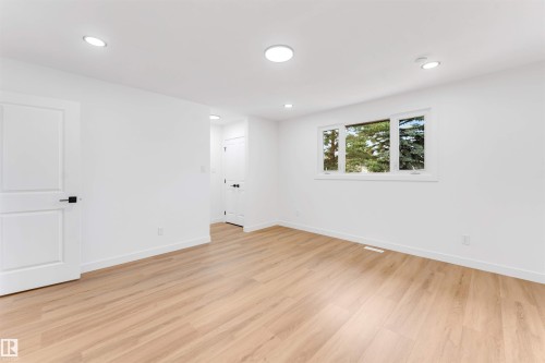 Bright interior space featuring wood-finish flooring, recessed lighting, and a white trim window - 5512 150 Avenue, Edmonton, AB 