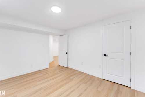 Room featuring wood-finish flooring, crisp white walls, and a recessed ceiling light - 5512 150 Avenue, Edmonton, AB 
