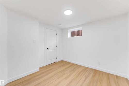 Room featuring light wood-finish flooring, white painted walls, and white baseboards - 5512 150 Avenue, Edmonton, AB 