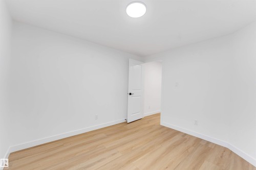 Bright interior space featuring light wood-finish flooring, white walls, and a recessed ceiling light fixture - 5512 150 Avenue, Edmonton, AB 