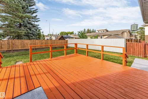 Expansive wood deck with vibrant orange finish, featuring matching railings - 5512 150 Avenue, Edmonton, AB 