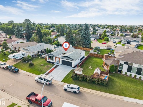 Modern single-story residence featuring a white exterior with black trim accents and a dark-pitched roof - 5512 150 Avenue, Edmonton, AB 
