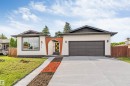 Contemporary single-story residence with a distinctive arched entry, a prominent two-car garage, and a broad concrete driveway - 5512 150 Avenue, Edmonton, AB 