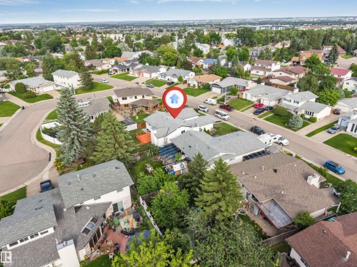 Single-story residence with a gray shingle roof, featuring an attached garage and mature landscaping - 5512 150 Avenue, Edmonton, AB 